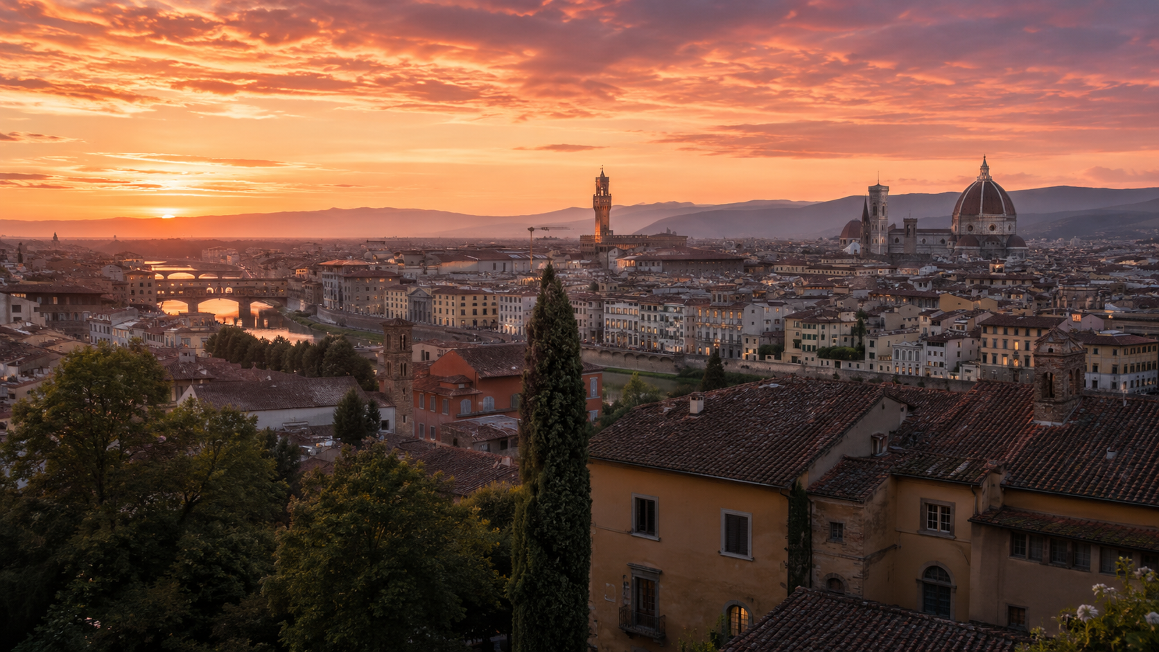 Vista panoramica dello skyline di Firenze al tramonto, con tetti in terracotta, il Duomo e torri storiche illuminate da un cielo caldo sui toni ambra e rosa.